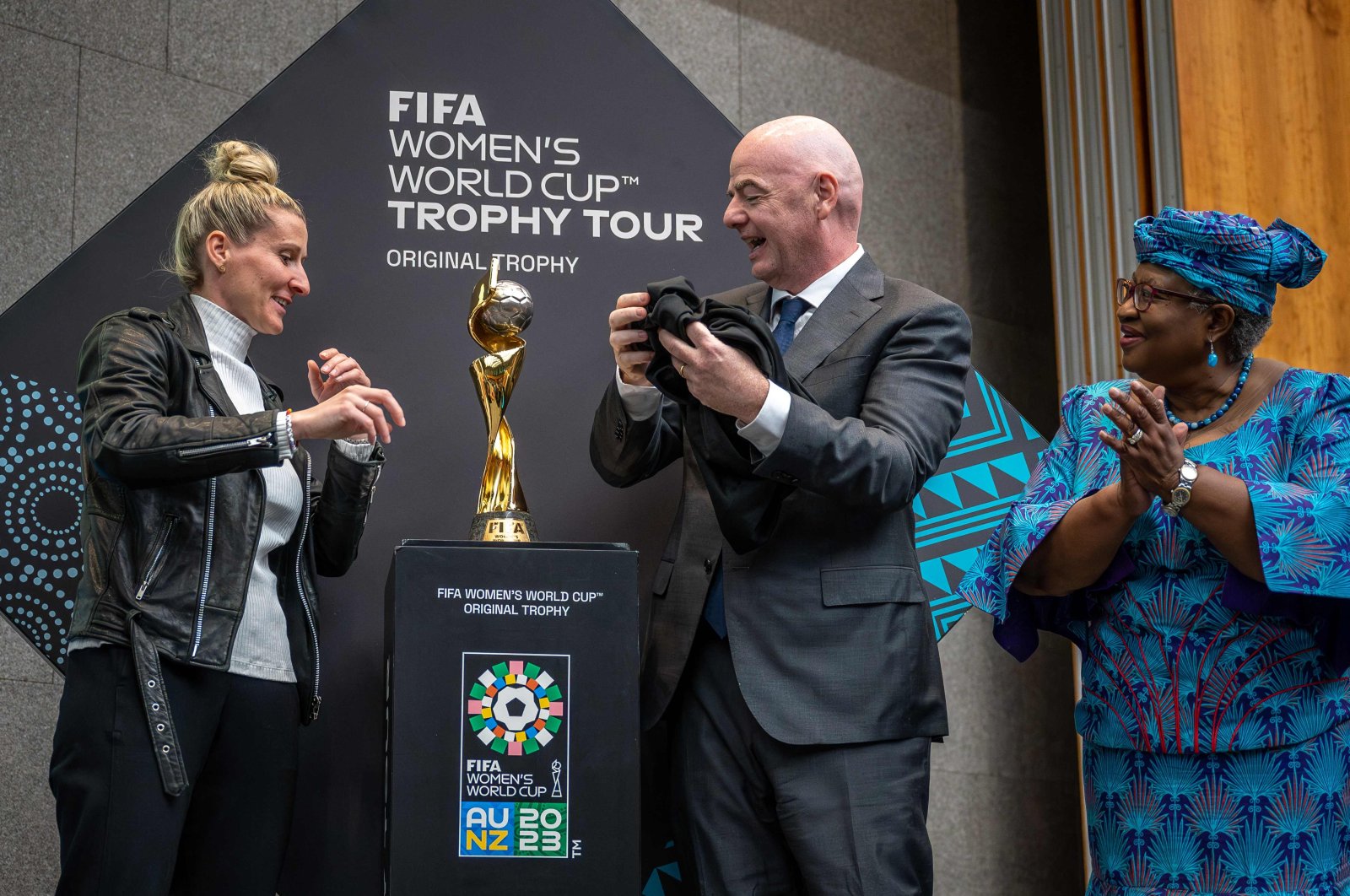 German forward Anja Mittag (L), FIFA President Gianni Infantino (C) and World Trade Organization (WTO) Director-General Ngozi Okonjo-Iweala (R) unveil the FIFA Women&#039;s World Cup trophy during the &quot;Making trade score for women!&quot; discussion on football as a tool for trade and development at the WTO headquarters, Geneva, Switzerland, May 1, 2023. (AFP Photo)