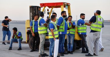 Workers from World Health Organization (WHO) and UAE-AID take a break after unloading aid from the United Arab Emirates at the Port Sudan International Airport, Port Sudan, Sudan, May 5, 2023. (Reuters Photo)