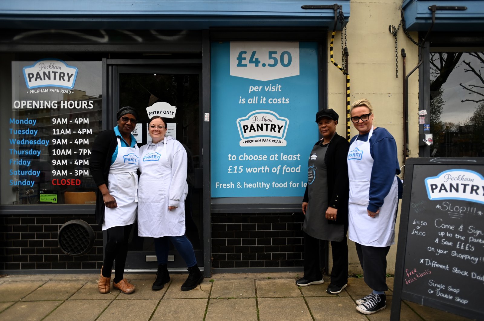 epa10592117 Pantry staff members pose for a photo in front of Peckham Pantry in London, Britain, 26 April 2023. People across the UK are using food banks and food Pantry stores more than ever according to food charity Trussel Trust. A record number, some three million food deliveries were given out in 2022. According to Trussel, one in five people using their food banks were in work, highlighting the difficulties families were facing with soaring energy costs and spiralling food inflation.  EPA/ANDY RAIN