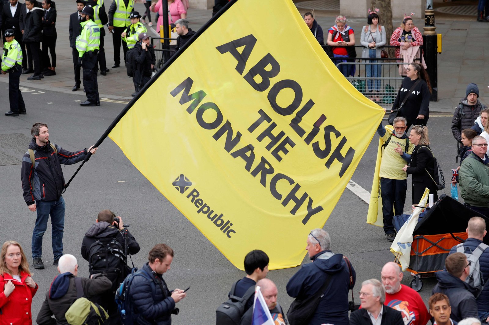 A protester holds a flag saying "Abolish the Monarchy" in Trafalgar Square close to where Britain&#039;s King Charles III and Britain&#039;s Camilla, Queen Consort will be crowned at Westminster Abbey, in London, U.K., May 6, 2023. (AFP Photo)