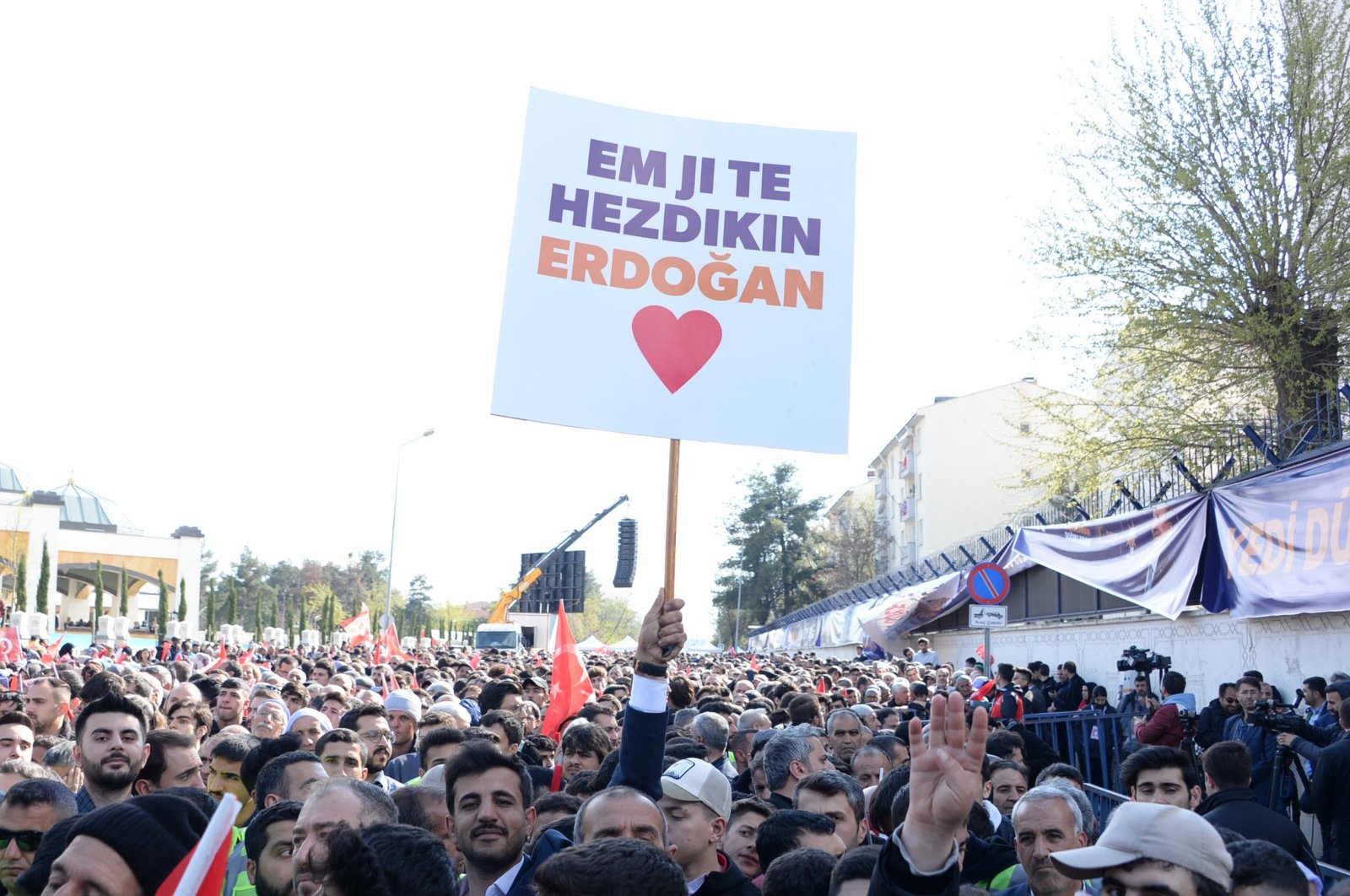 A supporter of President Recep Tayyip Erdoğan holds up a sign that reads "We love you, Erdoğan" in Kurdish during a ceremony in the southeastern Diyarbakır province, Türkiye, April 14, 2023. (DHA Photo)