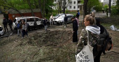People examine a crater near residential buildings made by remains of a shot-down Russian drone in Kyiv, Ukraine, May 8, 2023. (AFP Photo)