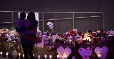 A woman holds her daughter at a growing memorial for victims of mass shooting in Half Moon Bay, Calif., U.S., Jan. 25, 2023. (AP Photo)