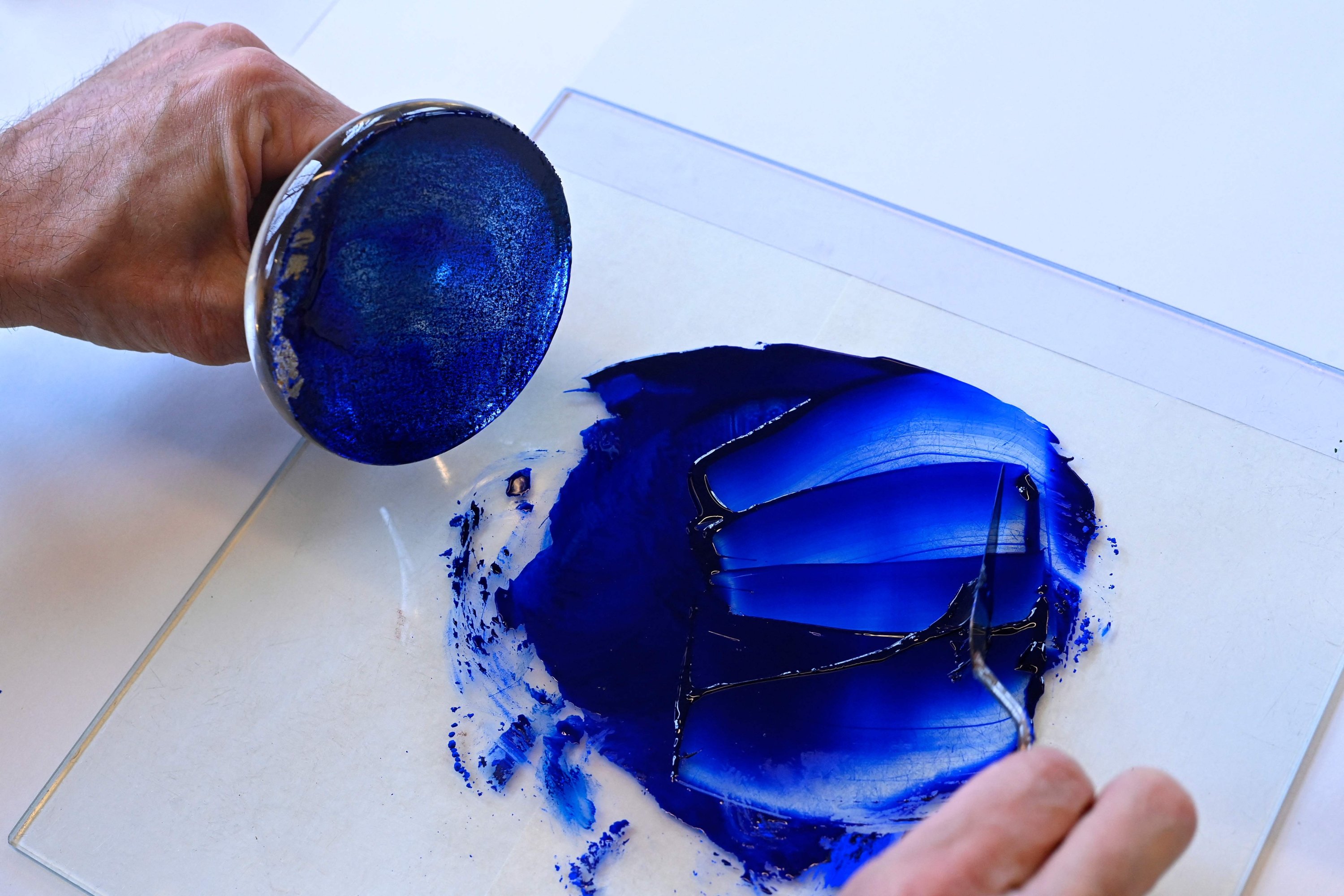 Peter Pelkmans, dosen sekolah menggambar Rijksmuseum, menghancurkan pigmen biru Lapis Lazuli di Amsterdam, Belanda, 6 April 2023. (Foto AFP)