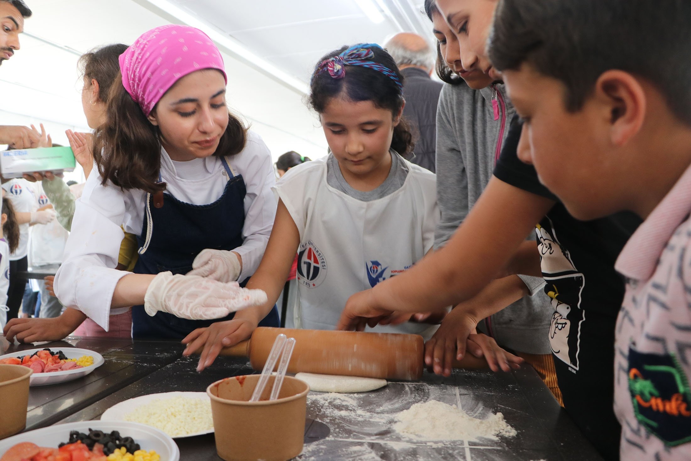 Mahasiswa universitas dan penyintas gempa muda membuat pizza, di Gaziantep, Türkiye, 8 Mei 2023. (Foto AA)