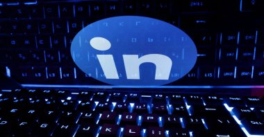 A keyboard is placed in front of a displayed LinkedIn logo in this illustration on taken Feb. 21, 2023. (Reuters Photo)