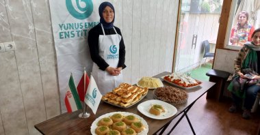 A woman participating in the cooking workshop organized by the Yunus Emre Insitute is seen with prepared dishes, Tehran, Iran, May 9, 2023. (AA Photo)