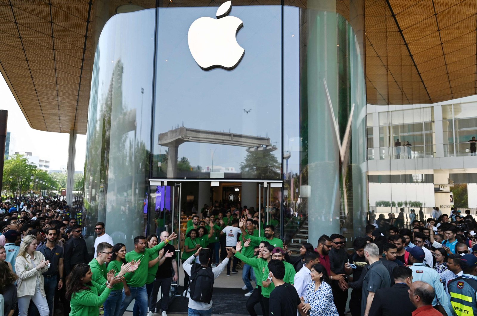 Apple employees (in green) cheer as they welcome customers during the inauguration of Apple&#039;s first retail store in Mumbai, India, April 18, 2023. (AFP Photo)