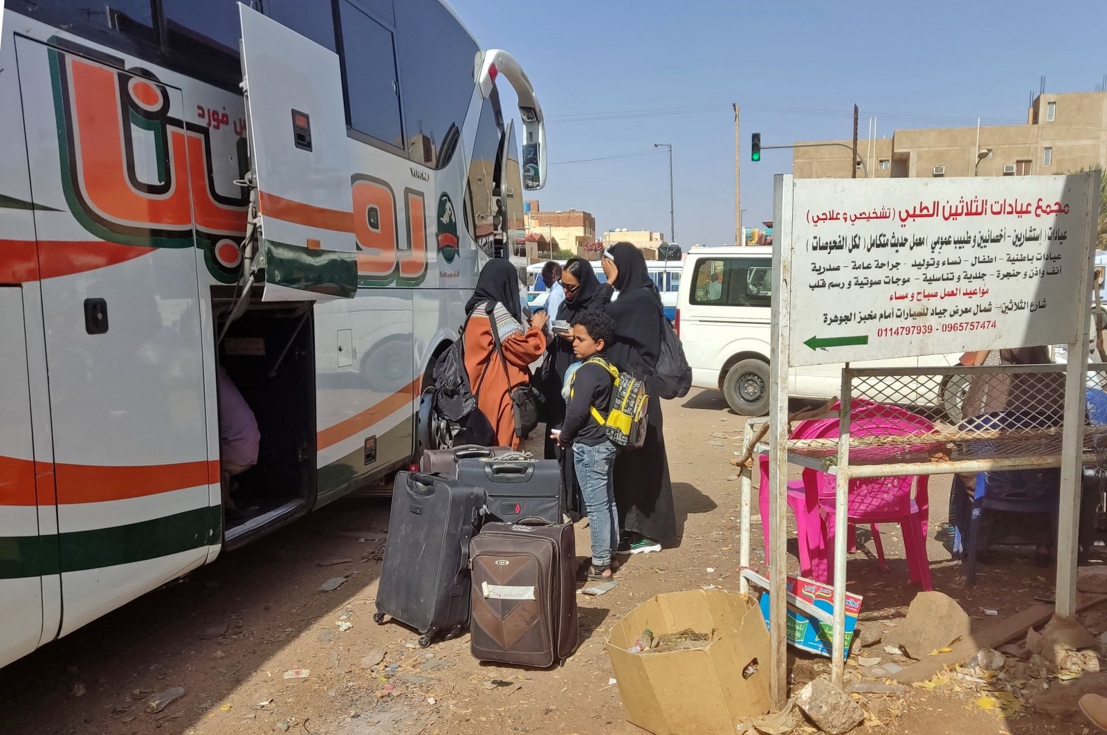 People wait with their luggage at a bus stop in southern Khartoum as fighting continues between Sudan&#039;s army and the paramilitary forces, May 8, 2023. (AFP Photo)