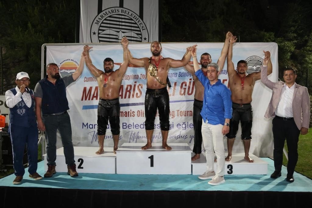Juara Ali Gürbüz (Tengah) merayakan setelah memenangkan kejuaraan gulat minyak Marmaris, Marmaris, Türkiye, 9 Mei 2023. (Foto IHA)