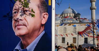 A woman walks past a campaign van showing the picture of President Recep Tayyip Erdoğan in Istanbul, Türkiye, May 8, 2023. (EPA Photo)