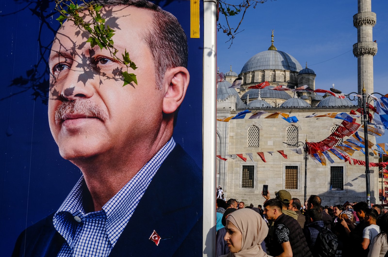 A woman walks past a campaign van showing the picture of President Recep Tayyip Erdoğan in Istanbul, Türkiye, May 8, 2023. (EPA Photo)