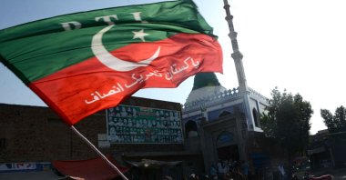 A supporter of Pakistan's former Prime Minister Imran Khan waves a Pakistan Justice Movement (PTI) flag during a protest against his arrest, in Multan, Pakistan, May 9, 2023. (EPA Photo)