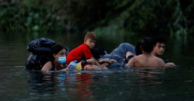 Migrants enter the Rio Bravo River to cross the border and turn themselves in to U.S. Border Patrol agents before Title 42 ends, Matamoros, Mexico, May 10, 2023. (Reuters Photo)