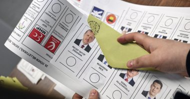 A voter holds a ballot for Turkish general elections with a photo of President Recep Tayyip Erdoğan at an election office at the Turkish embassy in Berlin, Germany, April 27, 2023. (EPA File Photo)