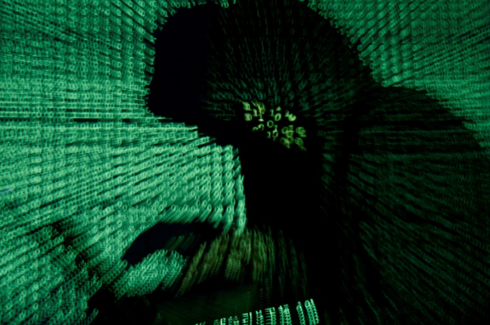 A man holds a laptop computer as cyber code is projected on him in this illustration picture taken on May 13, 2017. (Reuters Photo)