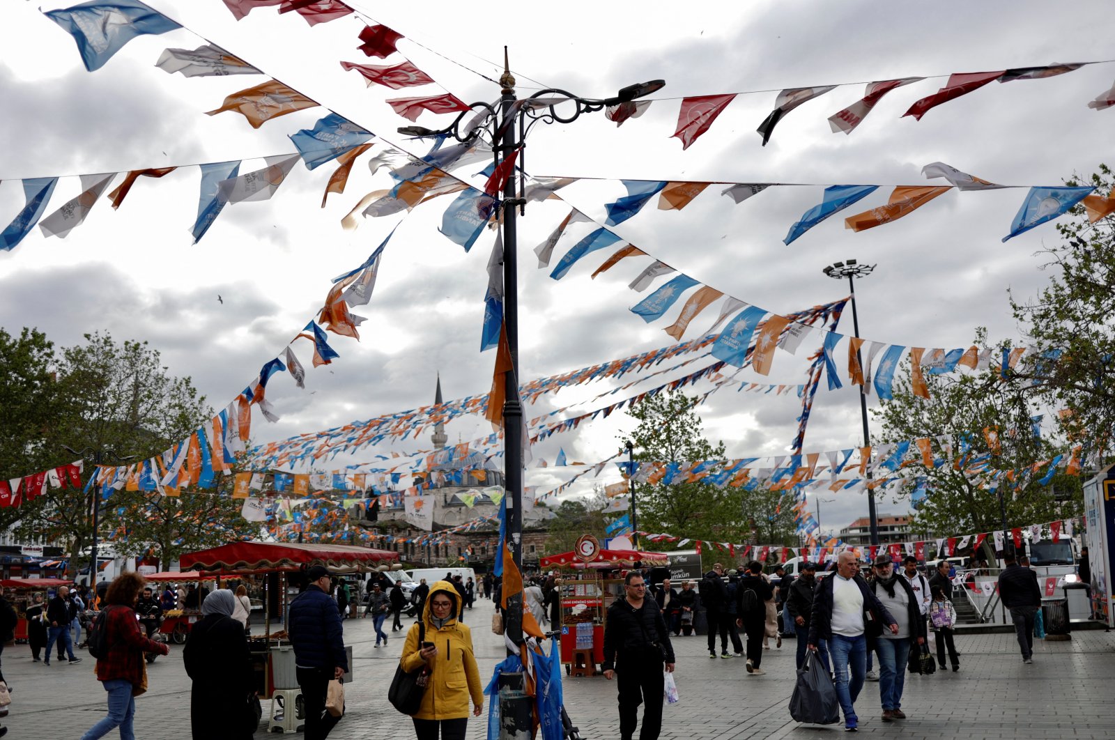 People walk at Eminönü Square decorated by President Recep Tayyip Erdoğan’s ruling Justice and Development Party (AK Party) flags ahead of the May 14 presidential and parliamentary elections, in Istanbul, Türkiye, May 10, 2023. (Reuters Photo)