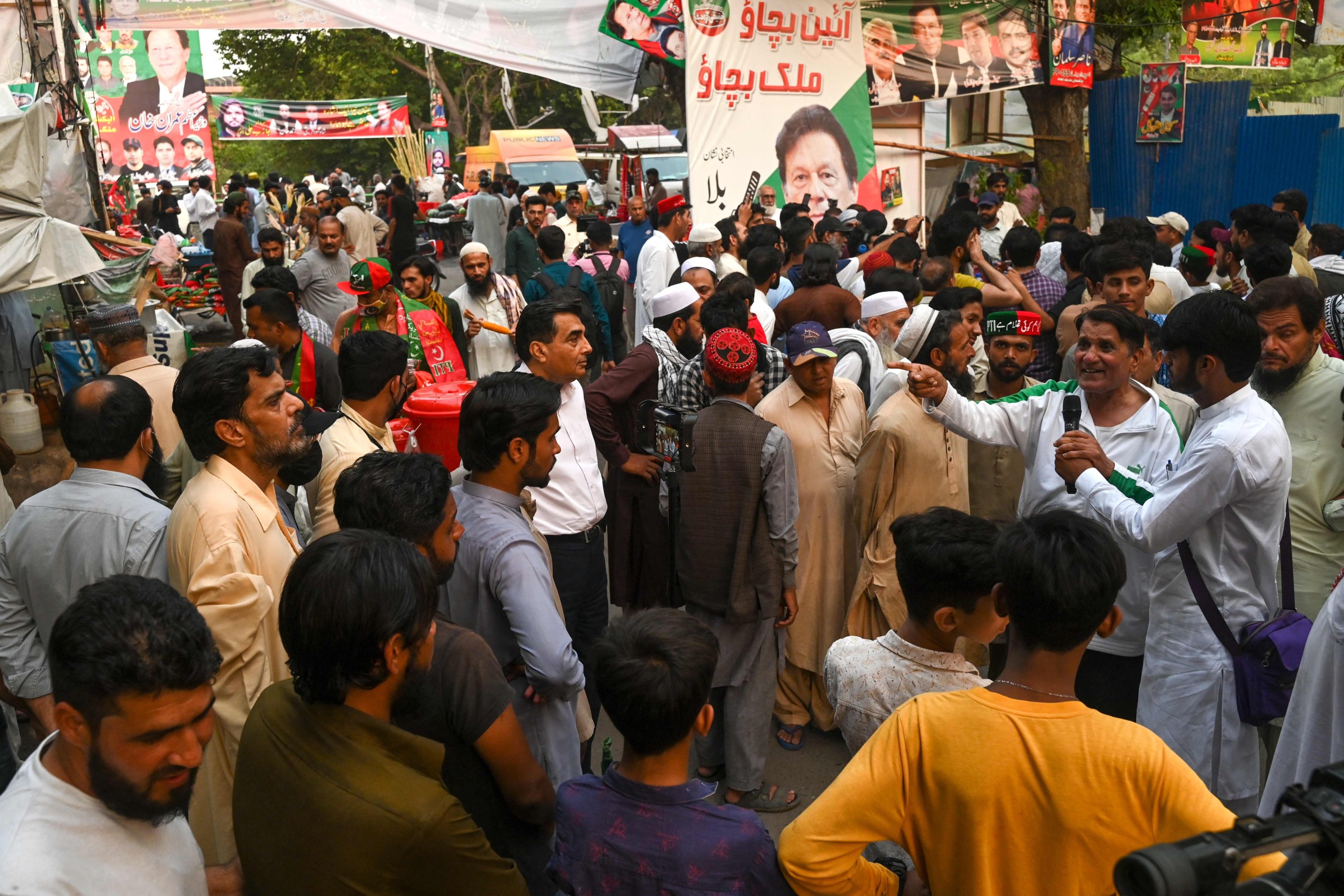 Aktivis dan pendukung partai Tehreek-e-Insaf (PTI) berkumpul di luar kediaman mantan Perdana Menteri Pakistan Imran Khan untuk mendengarkan pidatonya di Zaman Park, Lahore, Pakistan, 13 Mei 2023. (Foto AFP)