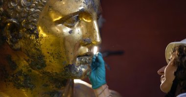 Vatican Museum restorer Alice Baltera works on the bronze Hercules statue, in the Round Hall of the Vatican Museums, Vatican, May 11, 2023. (AP Photo)