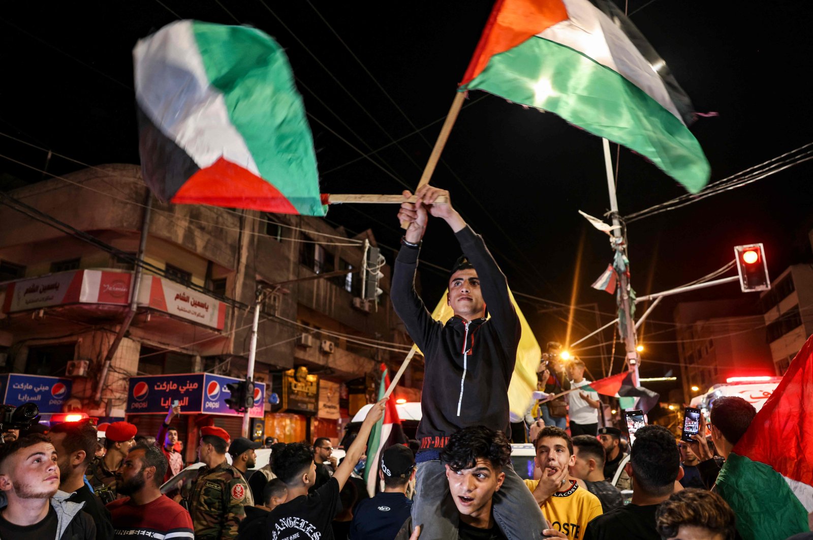 Palestinians and supporters of the Islamic Jihad group celebrate in the street after Palestinian factions and Israel reached a cease-fire agreement, Gaza City, Palestine, May 13, 2023. (AFP Photo)