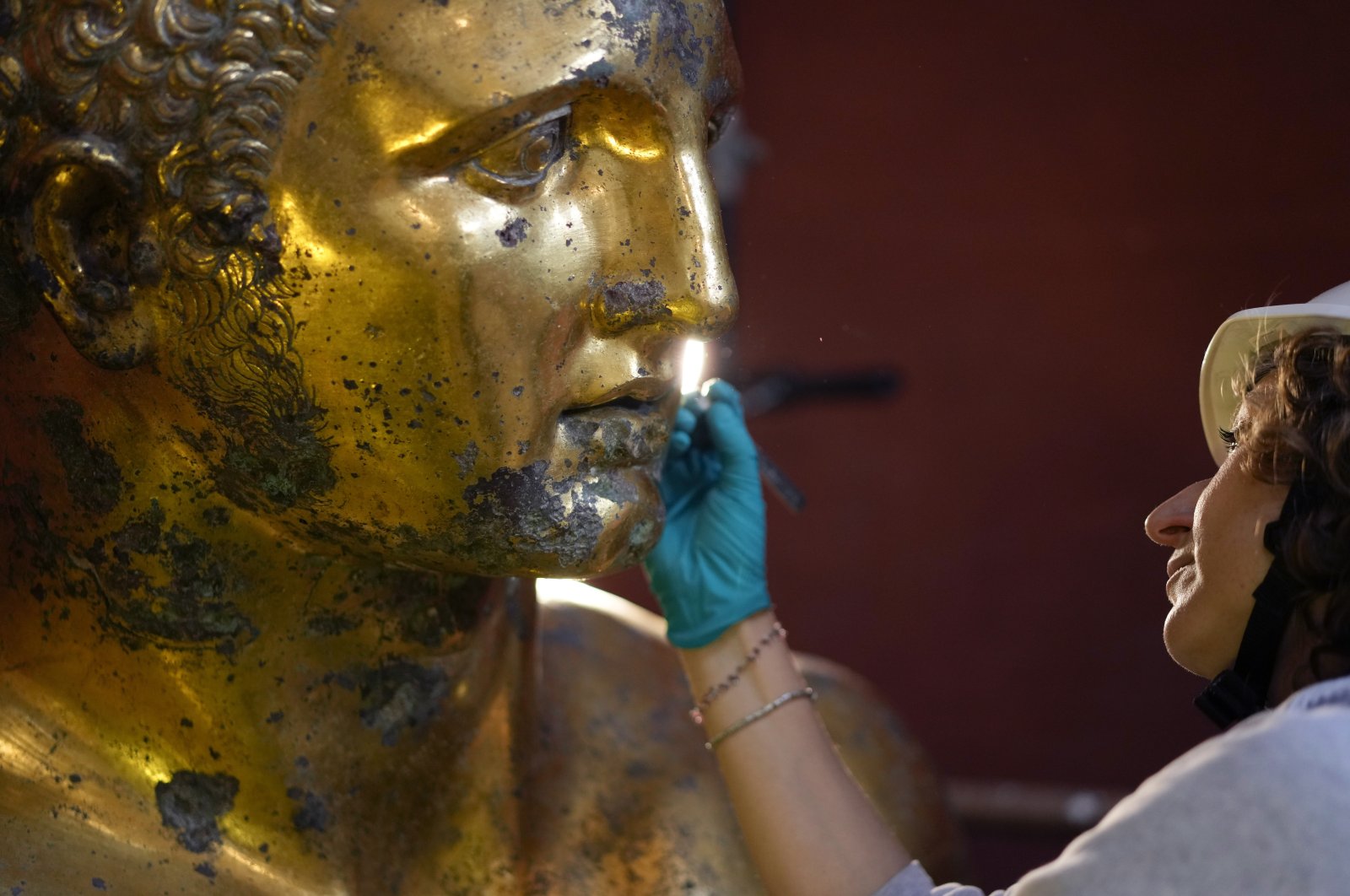 Vatican Museum restorer Alice Baltera works on the bronze Hercules statue, in the Round Hall of the Vatican Museums, Vatican, May 11, 2023. (AP Photo)