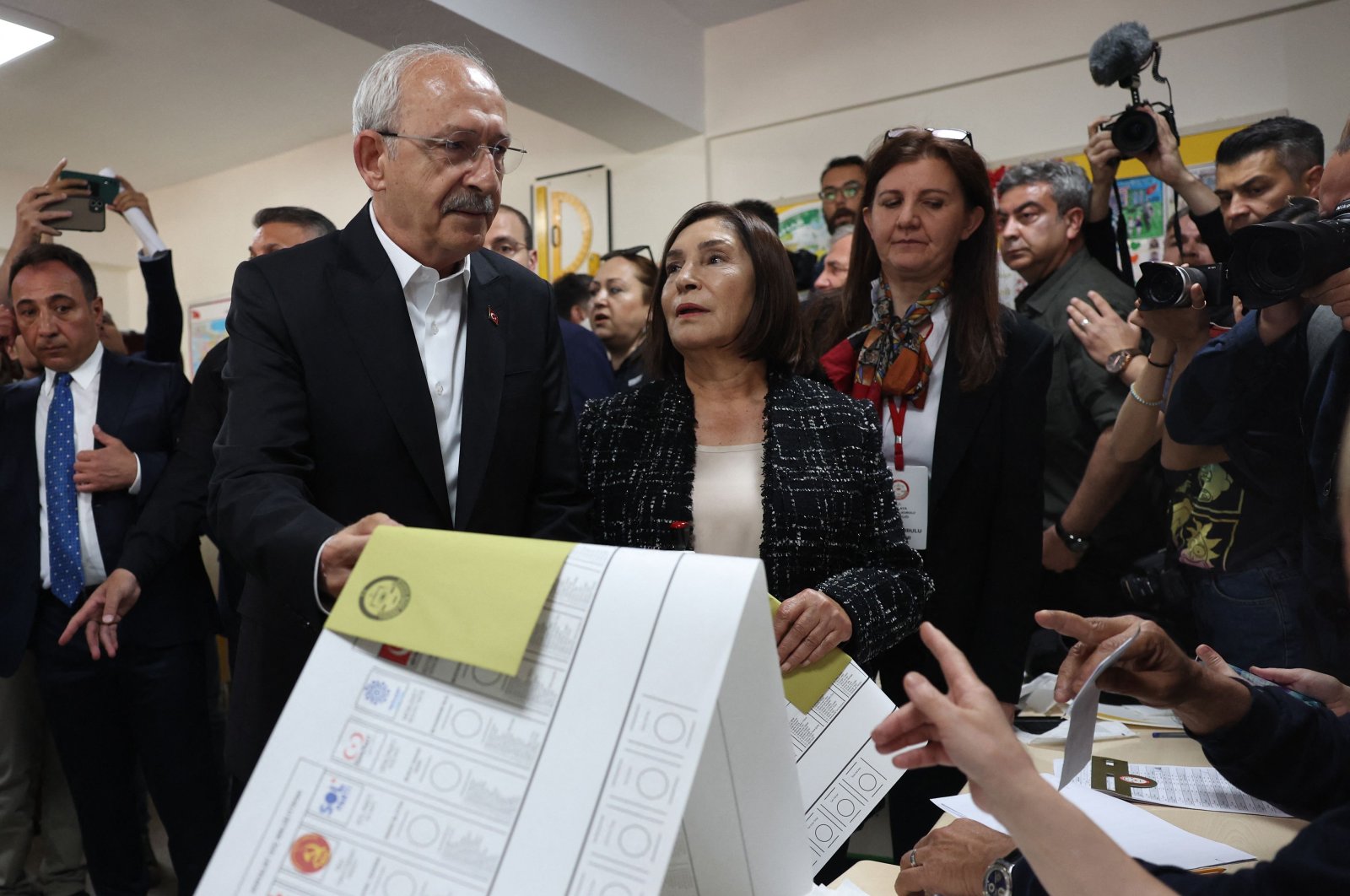 Kemal Kılıçdaroğlu (C), the 74-year-old leader of the main opposition Republican People&#039;s Party (CHP), and his wife Selvi Kılıçdaroğlu (R) hold their ballot papers as they prepare to cast their votes for the presidential and parliamentary elections, at a polling station in Ankara, Türkiye, May 14, 2023. (AFP Photo)