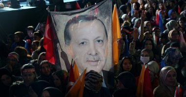 Supporters of Turkish President Tayyip Erdoğan hold a flag of his portrait outside the AK Party headquarters after polls closed in presidential and parliamentary elections in Ankara, Türkiye, May 15, 2023. (AFP Photo)