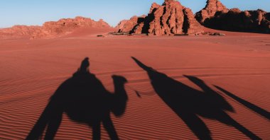 A group of people ride camels in Wadi Rum, in Jordan. (Getty Images Photo)