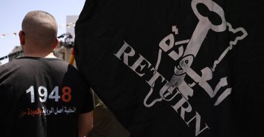A protester lifts a flag during a rally marking 'Nakba' day in the Ramallah city center in the occupied West Bank, on May 15, 2023. (AFP Photo)
