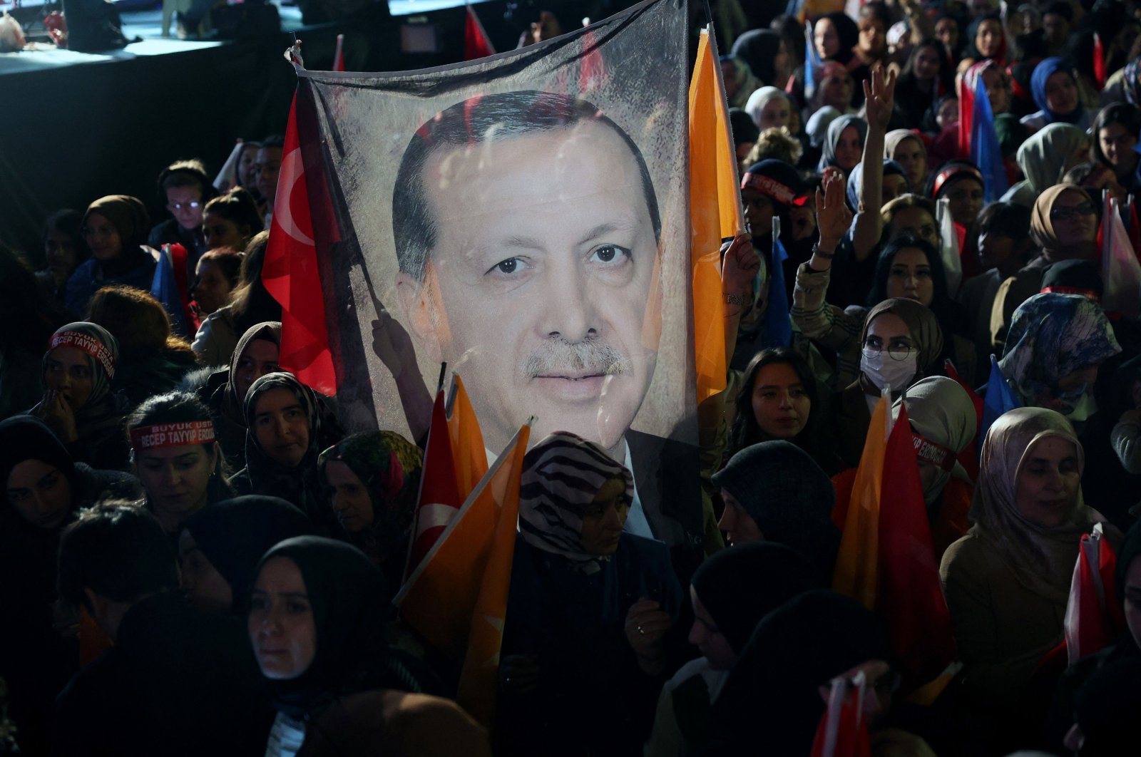 Supporters of Turkish President Tayyip Erdoğan hold a flag of his portrait outside the AK Party headquarters after polls closed in presidential and parliamentary elections in Ankara, Türkiye, May 15, 2023. (AFP Photo)