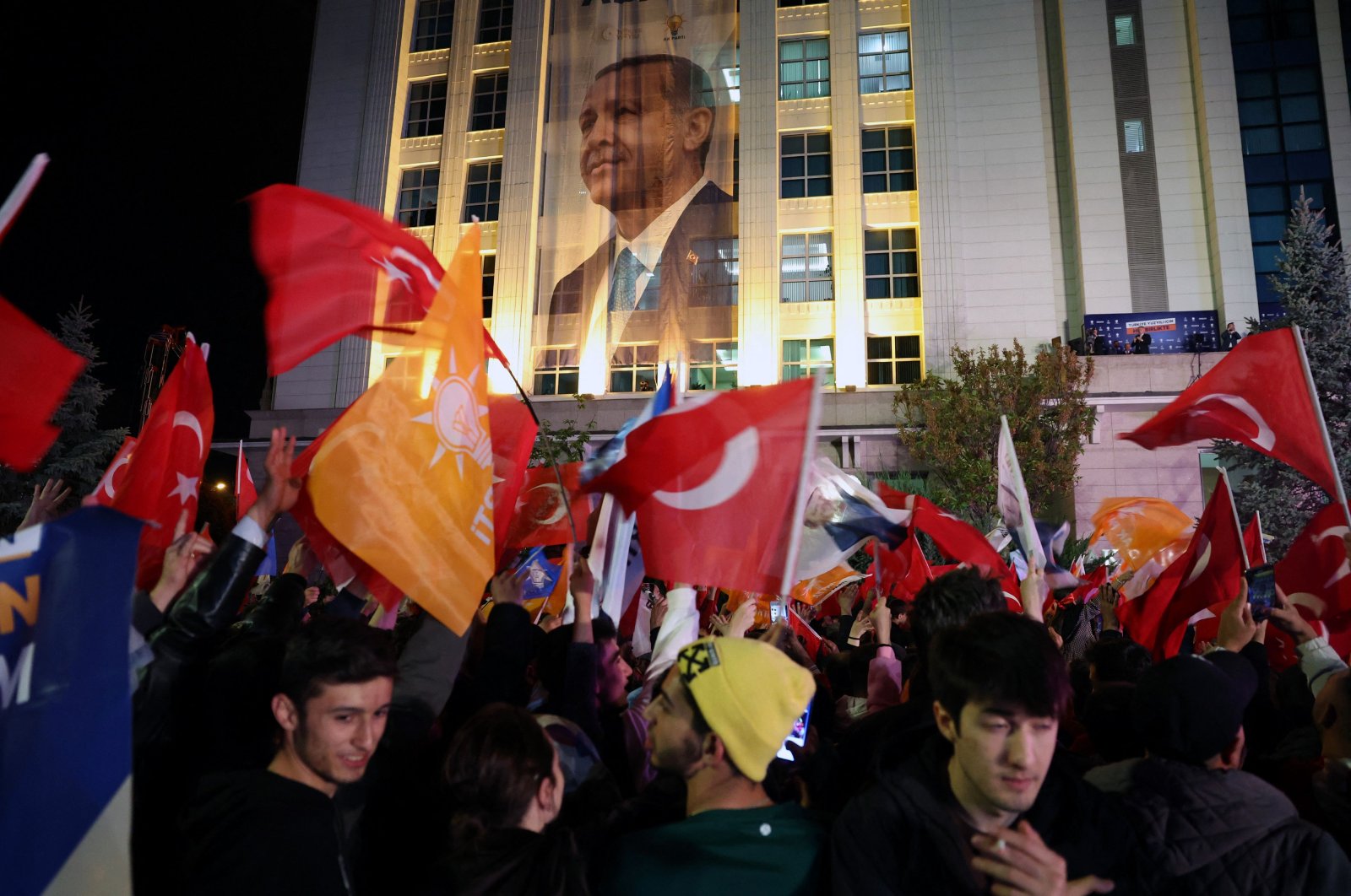 Supporters of President Recep Tayyip Erdoğan wave flags outside the Justice and Development Party (AK Party) headquarters, in the capital Ankara, Türkiye, May 15, 2023. (AFP Photo)