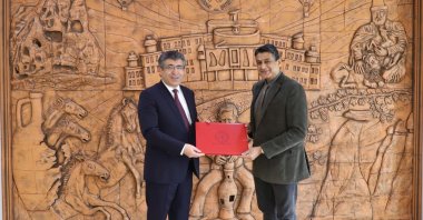 Professor Semih Aktekin (L), the rector of Nevşehir Hacı Bektaş Veli University (NEVÜ), presents a souvenir to professor Jameel-Un Nabi, the rector of the University of Wah, Nevşehir, Türkiye, May 16, 2023. (IHA Photo)