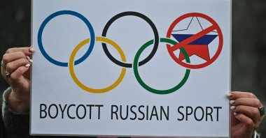 A protester in Krakow holds a powerful poster related to Summer Olympics in Paris and the words 'Boycott Russian Sport,' outside Krakow's Adam Mickiewicz monument, Krakow, Poland, March 31, 2023. (Getty Image Photo)