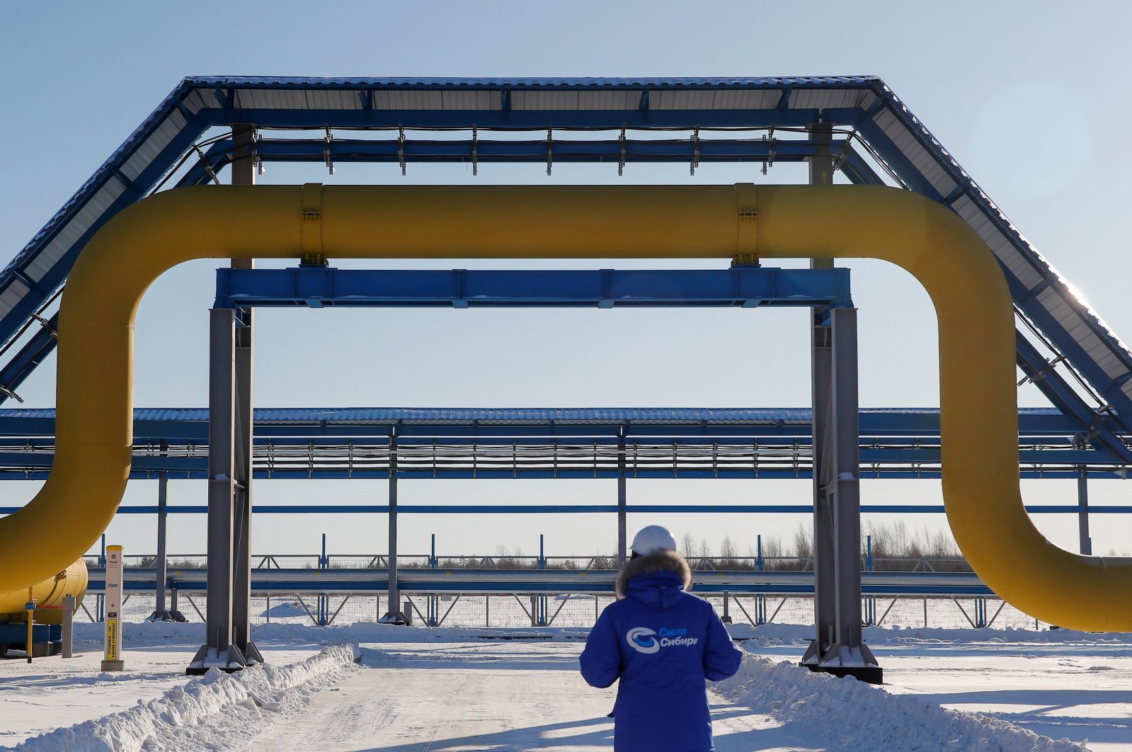 An employee in branded jacket walks past a part of Gazprom&#039;s Power Of Siberia gas pipeline at the Atamanskaya compressor station outside the far eastern town of Svobodny, in Amur region, Russia, Nov. 29, 2019. (Reuters Photo)