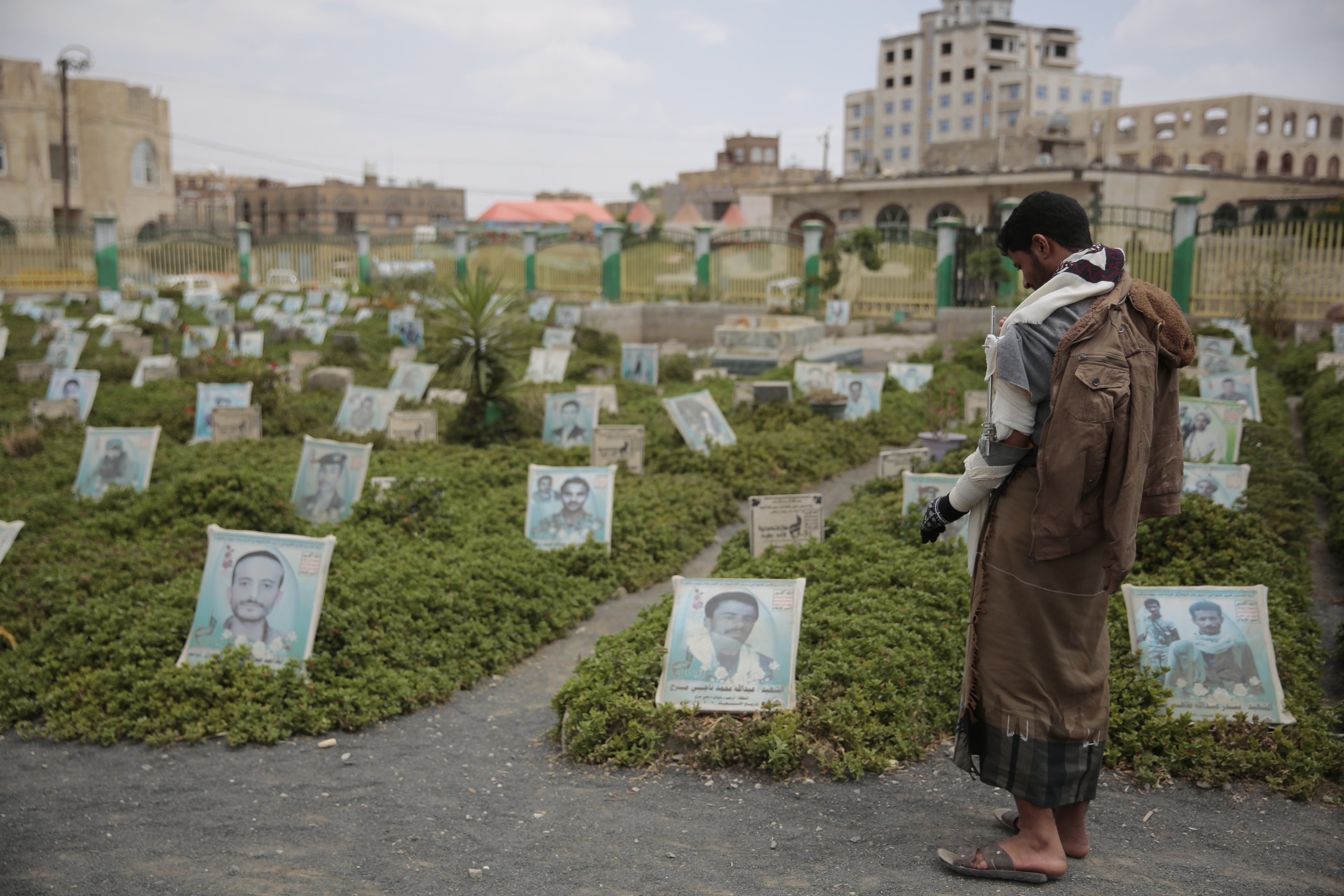 Seorang pendukung Houthi yang cacat karena perang berdoa di makam kerabatnya yang terbunuh dalam pertempuran baru-baru ini, di pemakaman di Sanaa, Yaman, 29 September 2021. (Foto AP)