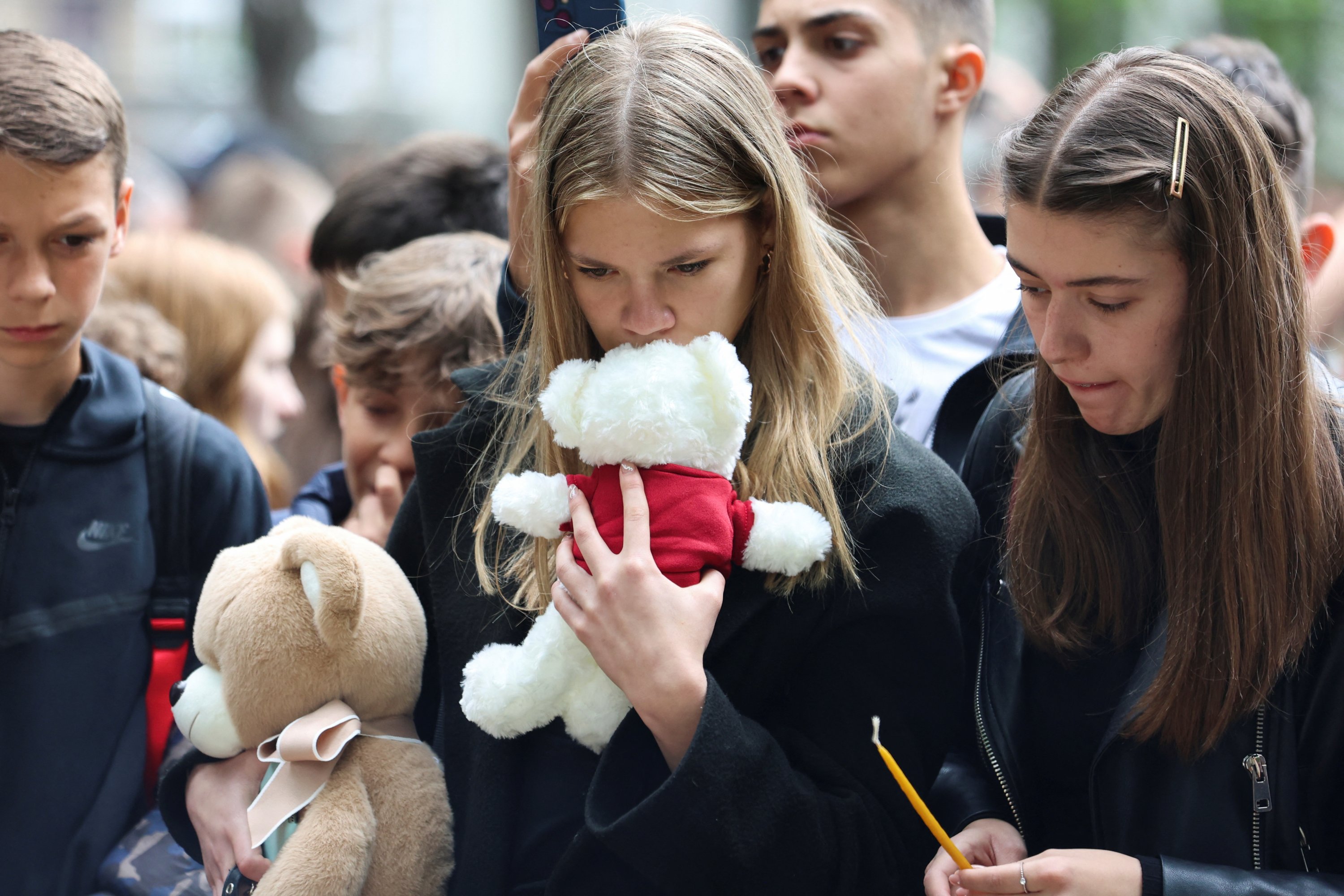 Orang-orang bereaksi saat memberikan penghormatan kepada para korban penembakan massal di sekolah, di Beograd, Serbia, 4 Mei 2023. (Foto Reuters)