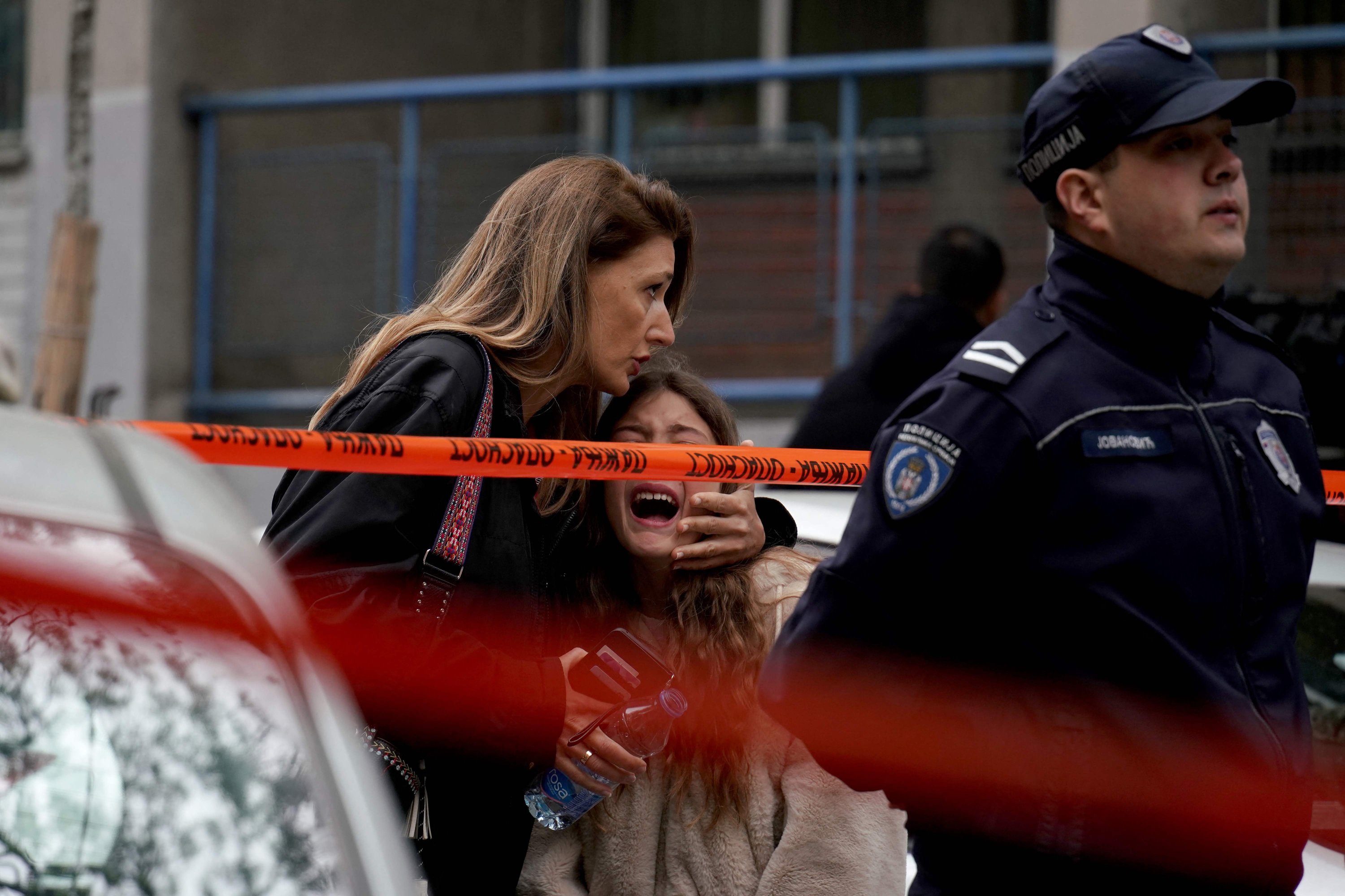 Seorang orang tua mengawal anaknya menyusul penembakan di sebuah sekolah di ibu kota Beograd, Serbia, 3 Mei 2023. (Foto AFP)