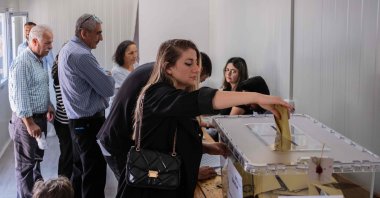 A voter casts her ballot in a container acting as an improvised polling station, in Hatay, southern Türkiye, May 14, 2023. (AFP Photo) 