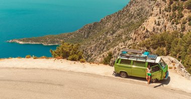 A young woman rests by her caravan on the side of a road, in Antalya, Türkiye, July 18, 2019. (Shutterstock Photo)
