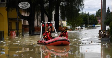 Firefighters ride their dinghy across a street flooded by the river Savio in the Ponte Vecchio district of Cesena, central eastern Italy, May 17, 2023. (AFP Photo)