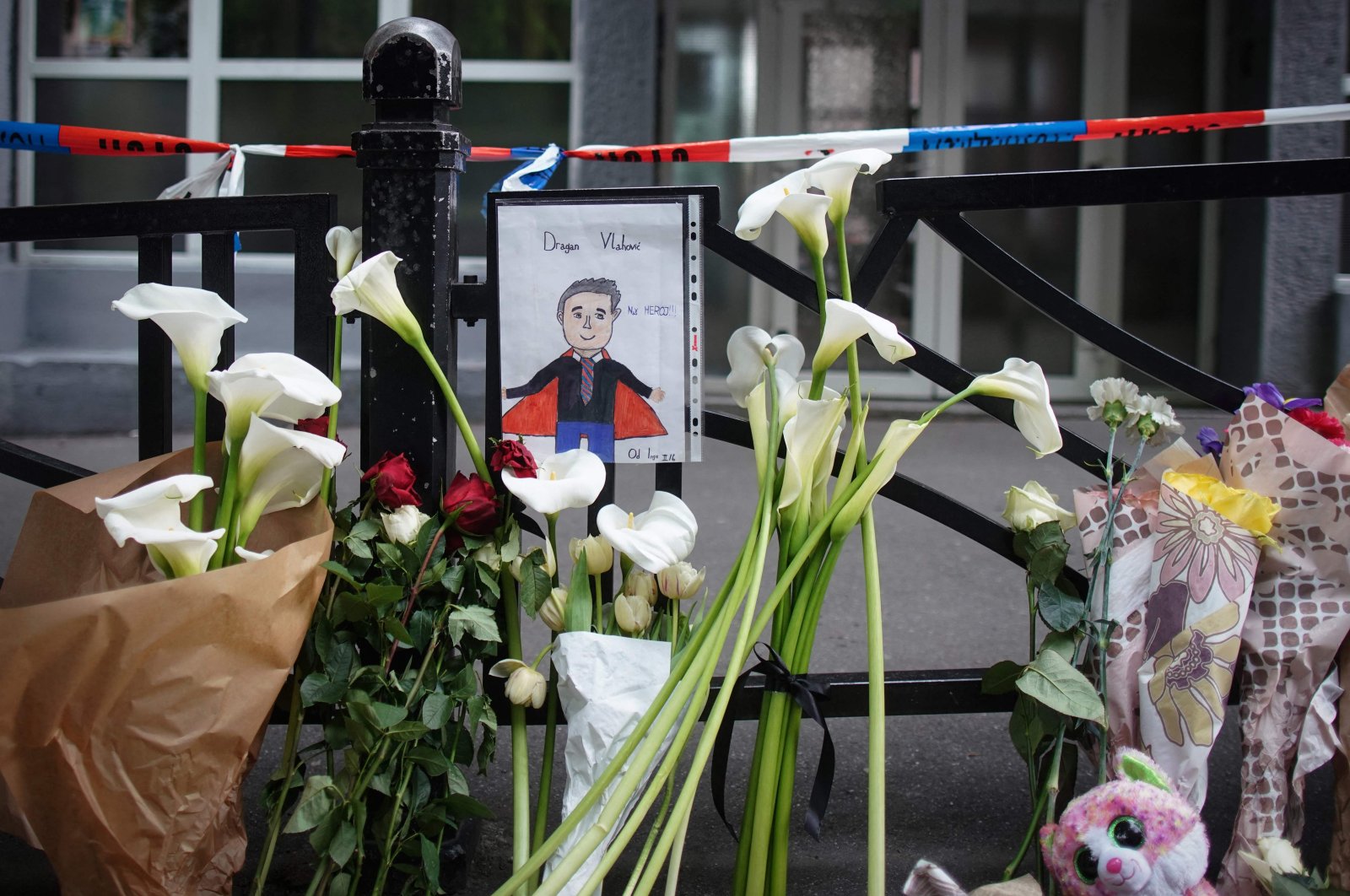 A drawing of security guard Dragan Vlahovic, who was killed in the attack, hangs on the fence of the Vladislav Ribnikar elementary school in the capital Belgrade, Serbia, May 4, 2023. (AFP Photo)