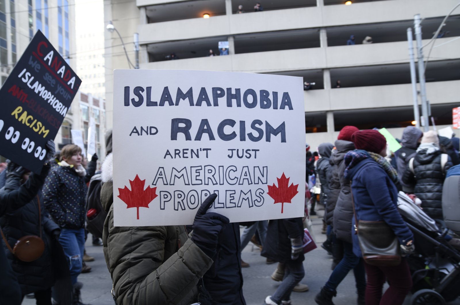 People with posters rejecting racism &amp; Islamophobia during a protest in front of the U.S. Consulate in Toronto to denounce Trump&#039;s immigration policies on Feb. 4, 2017. (Shutterstock File Photo)