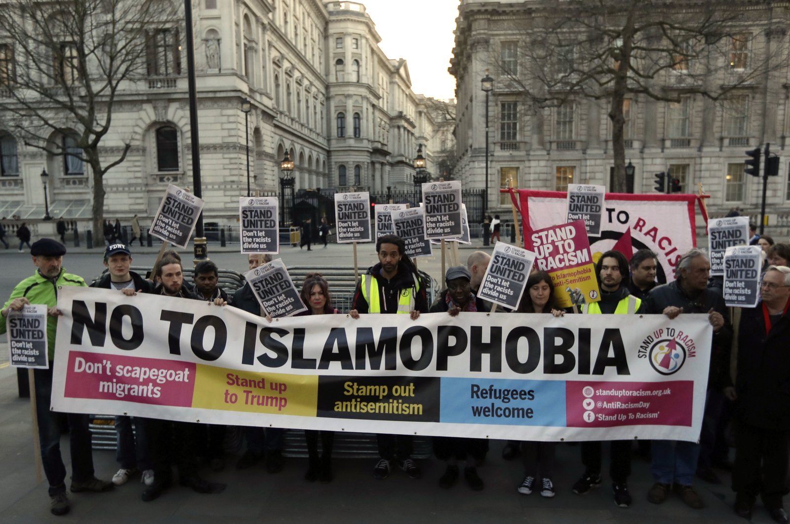 People hold up a banner during a &#039;Unity Vigil&#039; against racism and Islamophobia in reaction to Wednesday&#039;s attack, backdropped by the gates of Downing Street in London, Friday, March 24, 2017. (AP File Photo)