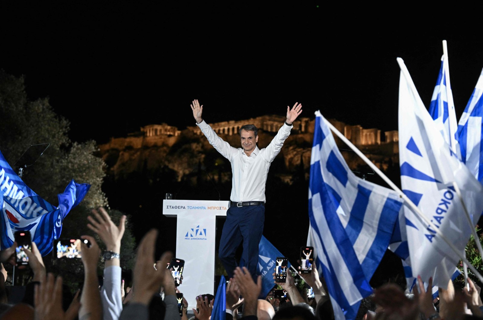 Greek Prime Minister and leader of the conservative New Democracy party Kyriakos Mitsotakis gestures as he addresses his party&#039;s supporters with the Acropolis hill in the background, in Athens, Greece, May 19, 2023. (AFP Photo)