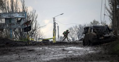 A Ukrainian serviceman runs for cover from shelling across a street in the frontline town of Bakhmut, Donetsk, April 23, 2023. (AFP Photo)
