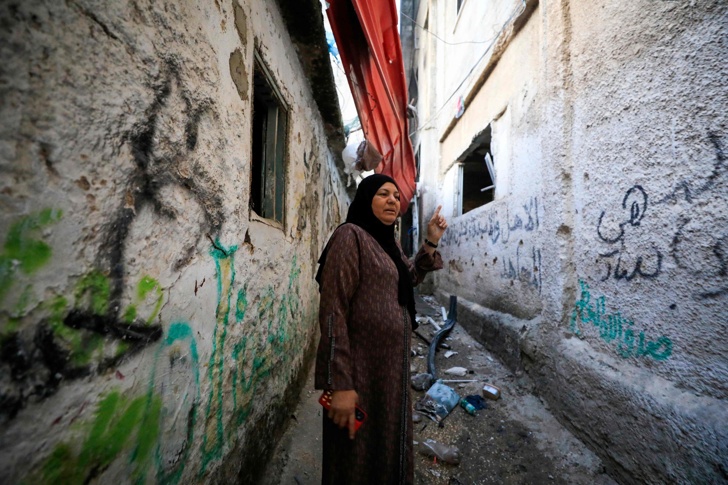 Seorang wanita Palestina memeriksa bangunannya yang rusak setelah serangan tentara Israel di kamp pengungsi Balata dekat kota Nablus, Tepi Barat yang diduduki, Palestina, 22 Mei 2023. (Foto AFP)