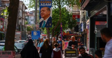 People walk past a banner of President Recep Tayyip Erdoğan in Ankara, Türkiye, May 13, 2023. (Reuters Photo)