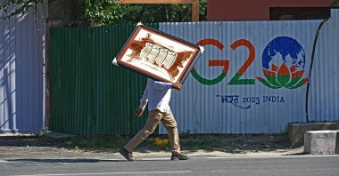 A man walks in front of a fence carrying the G-20 logo, in Srinagar, India-administered Kashmir, May 22, 2023. ( Faisal Khan - Anadolu Ajansı )