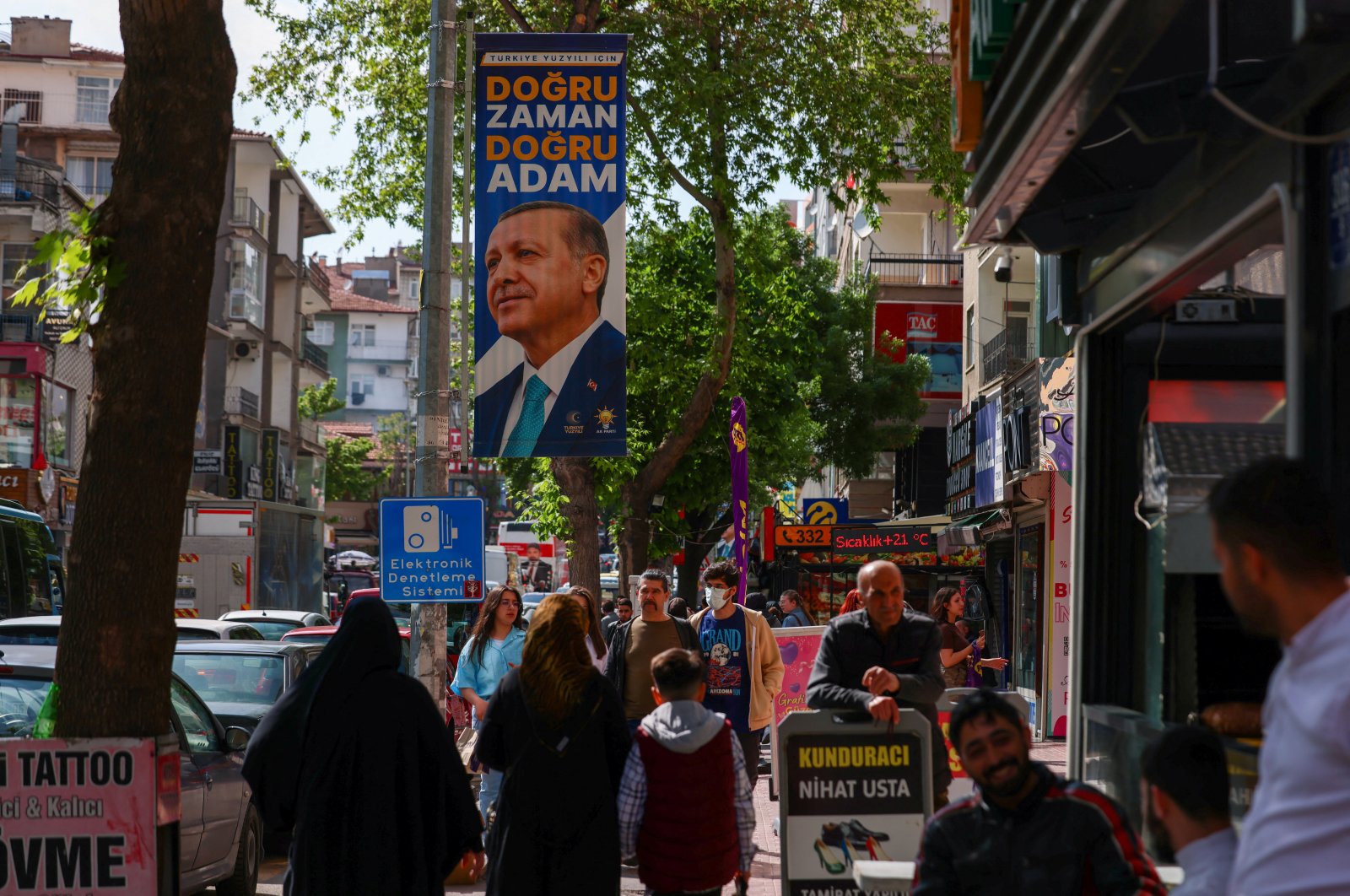 People walk past a banner of President Recep Tayyip Erdoğan in Ankara, Türkiye, May 13, 2023. (Reuters Photo)