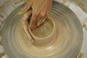 A woman makes a jug from raw wet clay in this undated photo. (Shutterstock Photo)